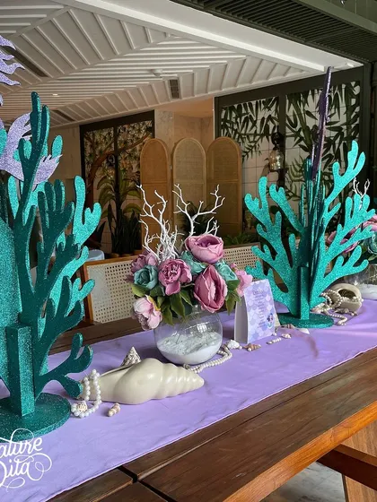 The table centrepieces featured glittery coral props, seashells, pearls, and floral arrangements, creating a beautiful underwater tablescape.