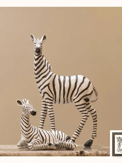 This pair of zebra sculptures, one standing and one resting, creates a serene and stylish wildlife scene. The classic black and white pattern makes it a timeless addition to any decor.