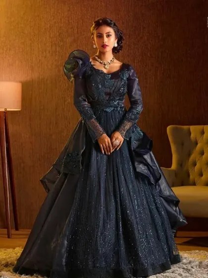Rent, wear, and shine in our beautiful gowns. This dark blue gown with dramatic sleeves is perfect for creating an unforgettable look.