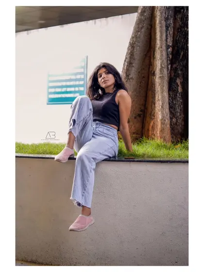 A relaxed, full-body portrait in an urban setting. The pose is casual and confident, perfect for a lifestyle or fashion shoot.