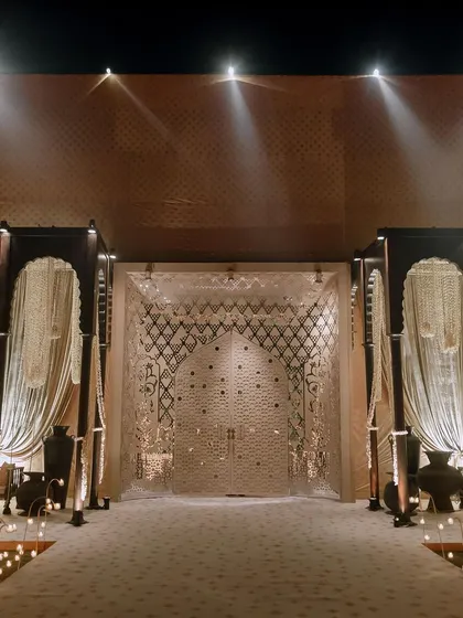 The grand entrance to the Sufi night, with a pathway lit by candles leading to an intricately designed doorway. This sets a dramatic and serene tone from the moment guests arrive.