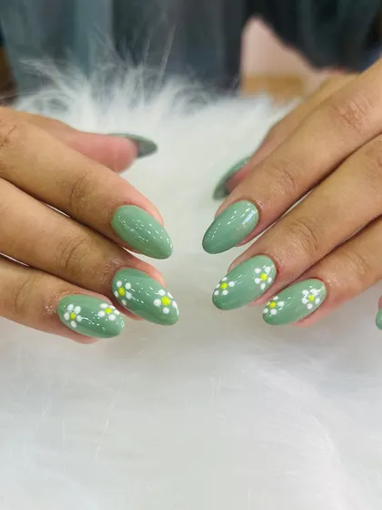 A fresh and earthy green manicure. This set features an olive green base with small, hand-painted white daisies for a simple and cute look.