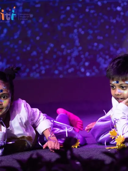 Two children dressed as stars lie on the stage, creating a beautiful celestial scene. Their performance was filled with charm and wonder.