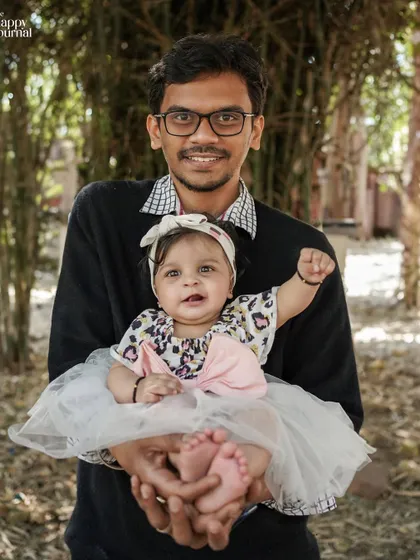 A father holds his baby daughter in his hands, showcasing just how small and precious she is. A beautiful outdoor portrait full of love.