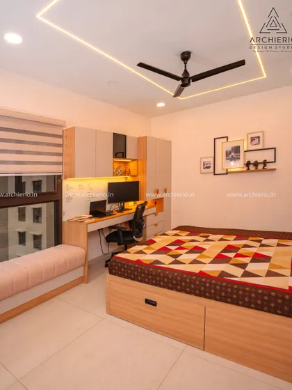 A multi-functional bedroom with a bed, a long study desk, and a window seat, all designed with a cohesive light wood and white theme.