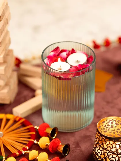 Floating tea lights in a glass vase with rose petals. This is a classic, elegant decor shot that evokes a sense of peace and celebration.