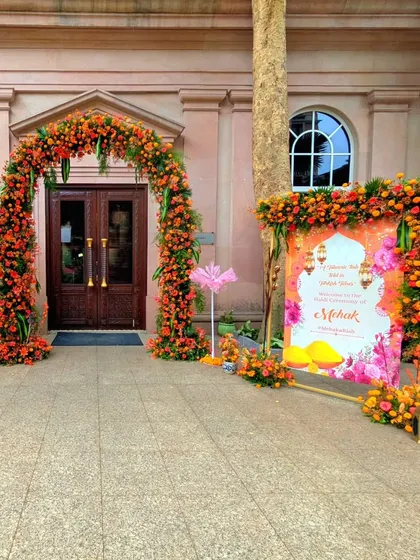 The entrance to this Turkish-themed Haldi ceremony featured a vibrant floral arch in shades of orange and red, perfectly framing the doorway and setting a festive mood.