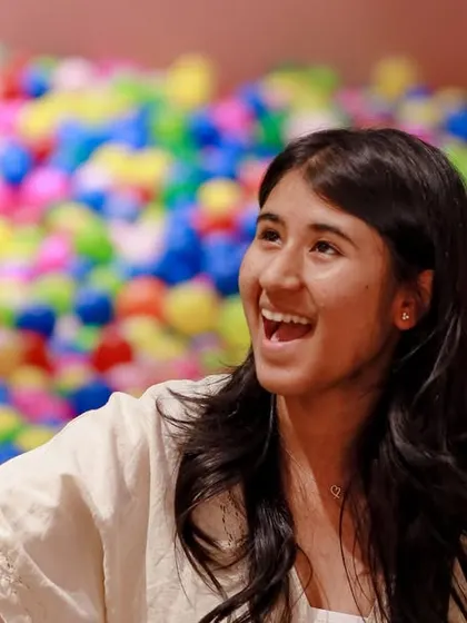 An adult guest enjoying the fun and watching the kids play in the ball pit during a party.