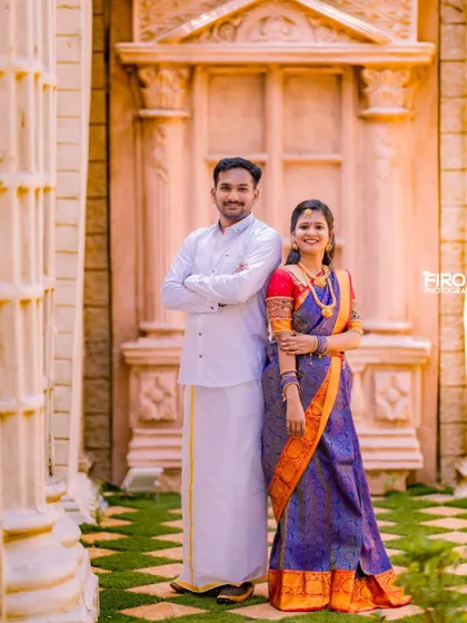 An elegant portrait of a couple in traditional South Indian attire. The classic pose and the grand architecture make for a timeless pre-wedding photo.