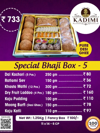 A premium Bhaji Box filled with a mix of sweets and namkeen, including Dal Kachori, Ratlami Sev, Dry Fruit Laddoo, Moong Burfi, and Kaju Katli.