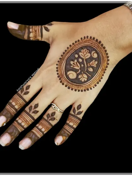 A minimalist design featuring a single floral motif in an oval frame on the back of the hand. This is perfect for someone who wants a small but beautiful touch of henna.