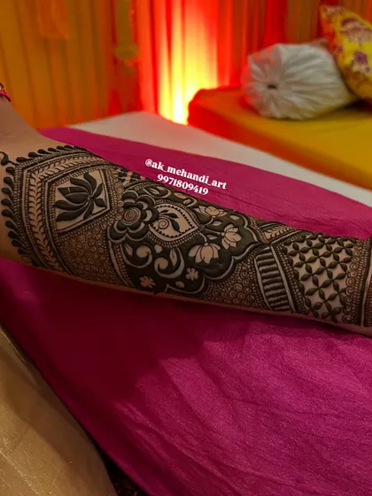 A close-up of a bridal arm design with lotus motifs and intricate geometric fillers.