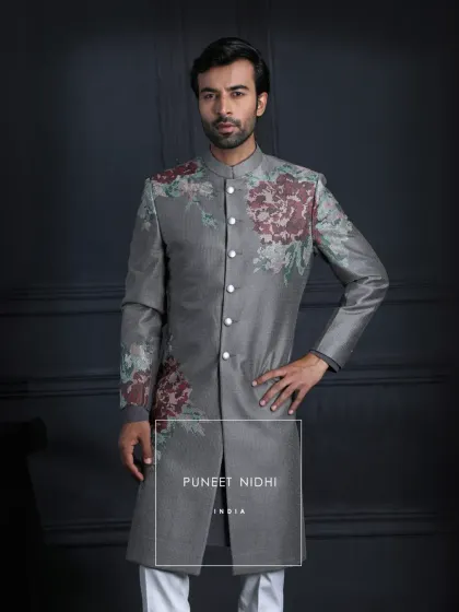 An Achkan of contrasts. A deep charcoal grey base is embroidered with blooming vintage roses, redefining classic tailoring with floral finesse.