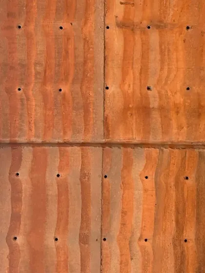 A close-up of the beautiful, almost painterly texture of a finished rammed earth panel.