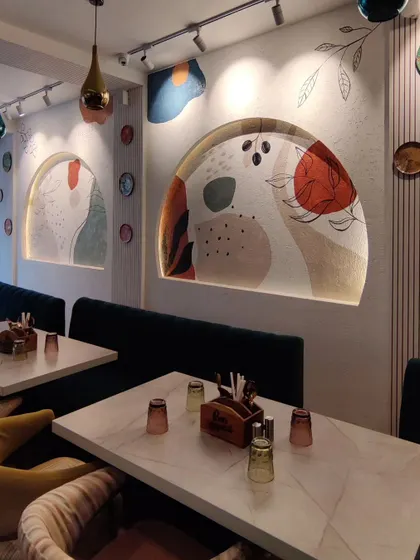 Another perspective of the main dining wall at Cafe Berni, showing the interplay between the two arched murals.