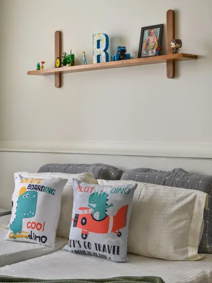 This kid's room from our 'Malhar' project features a custom wooden ledge for holding books and toys. The design is both functional and charming, adding a touch of craftsmanship to the space.