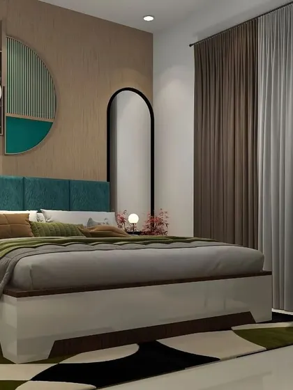 A bedroom with a striking teal blue upholstered headboard and matching chair. The design is complemented by unique circular wall art and an arched full-length mirror.