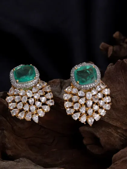 These statement studs are designed for maximum impact. They feature a large, rectangular emerald-colored stone surrounded by a halo of brilliant American Diamonds, with a cascade of smaller stones below.