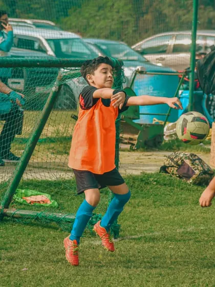 A young goalkeeper throws the ball out to start an attack.