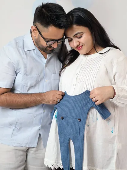 This couple is getting ready for their baby boy with a cute blue outfit. We have a variety of these tiny props to help you make your announcement special.