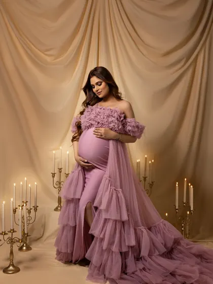 A regal, seated portrait in a dusty rose ruffled gown, surrounded by the romantic glow of candles.