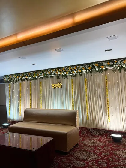 Another angle of the sophisticated Haldi backdrop, showing the soft lighting and delicate marigold strings that add a touch of tradition.