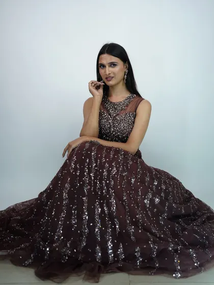 A seated portrait in the brown sequined gown, showing the beautiful drape of the skirt.