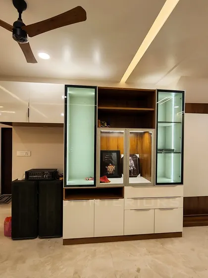 A custom-built crockery and display unit featuring a mix of closed cabinets and glass-front shelves with integrated lighting. This functional piece adds a touch of elegance to the living area.