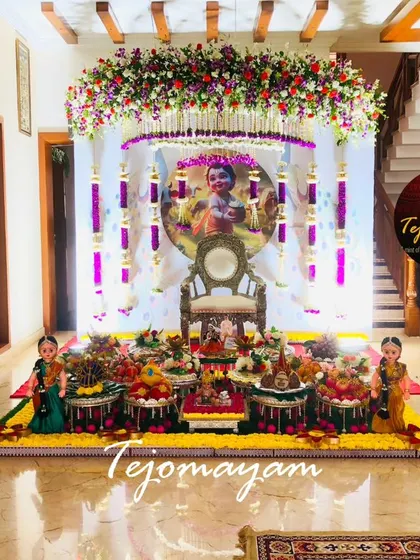 A beautiful baby shower setup in a home, with a Krishna-themed backdrop and silver lamps, showing how I can transform any space.