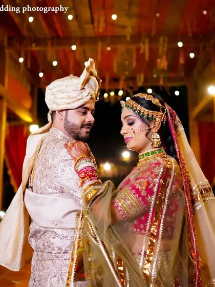 A beautiful, warm-toned photo of Harshil and Aditi sharing a quiet moment. The bride's hand on the groom's chest and their gentle expressions convey deep affection.