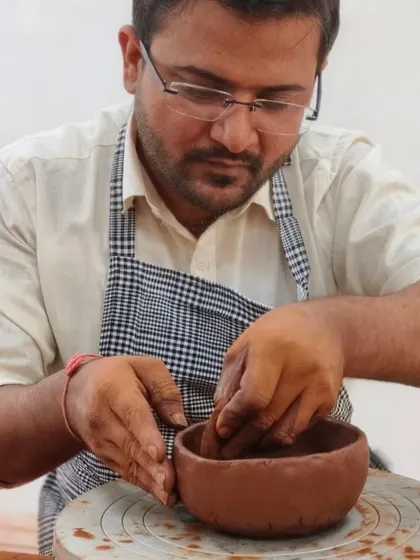 A student uses the pinching method to form a small bowl. This is one of the most fundamental and intuitive hand-building techniques we teach to beginners.