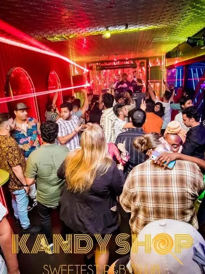 A wide view of the party at Kandy Shop, with colorful lights illuminating a full house. I work to build the energy throughout the night.