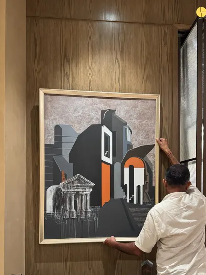 The final layer of design is often the art. A craftsman carefully positions a large painting in a corporate project, a piece that will become a focal point and conversation starter in the new space.