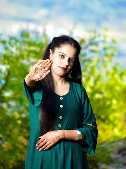 A candid and gentle pose, highlighting the mehndi design on the bride-to-be's hand.