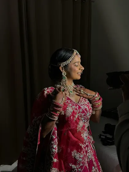 A behind the scenes shot during the bride's photoshoot, capturing her serene profile and the beautiful details of her makeup.