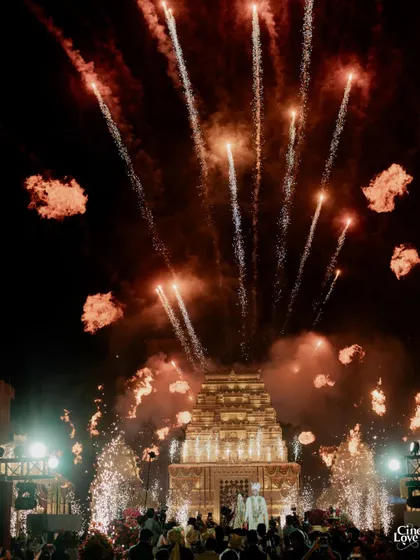 A spectacular display of fireworks erupts behind the temple mandap, marking a crescendo in the celebration. Such moments of dramatic flair are woven into my designs to create unforgettable memories.