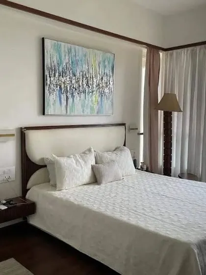 A simple yet elegant bed with a curved, upholstered headboard and floating wooden nightstands. This design is perfect for creating a light and airy feel in a contemporary bedroom.