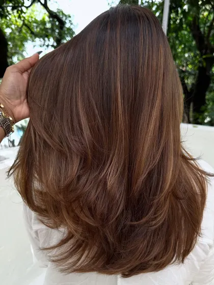 The back view of her color refresh. We added subtle highlights to her brunette hair for a natural, sun-kissed look.