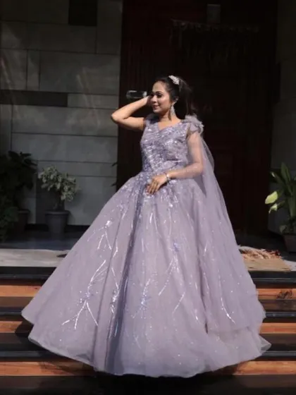 Feel like a princess in this lilac ball gown. The shimmering fabric and voluminous skirt create a magical effect, especially under evening lights. It's a true showstopper available for rent for your most important celebrations.