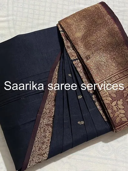 A classic black saree with a gold border. The pleats are perfectly set for a timeless and elegant drape.