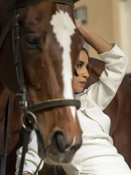 This image captures a gentle moment, with the model stroking the horse. It adds a storytelling element, blending fashion with a narrative of companionship and nature.