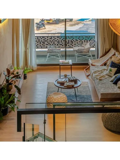 A view from the upper level looking down into the family lounge. The use of glass railings maintains visual openness across the split levels.