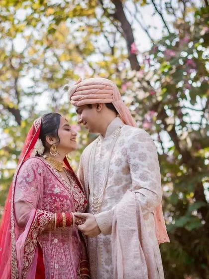 A sweet, interactive moment between the couple. They are holding hands and looking at each other, their expressions full of love and happiness.