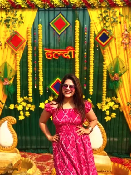 A full-length shot in front of the Haldi backdrop. Ready to get the party started.
