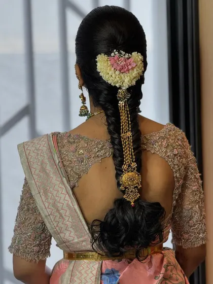 This bride's hairstyle perfectly complements the intricate back design of her custom blouse. The combination of traditional flowers and modern design is simply stunning.