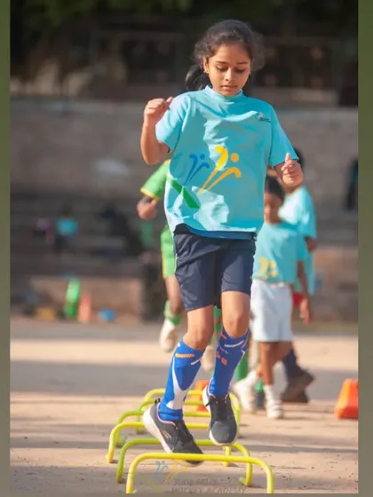 A girl from our 2022 camp works on her agility with hurdle drills.