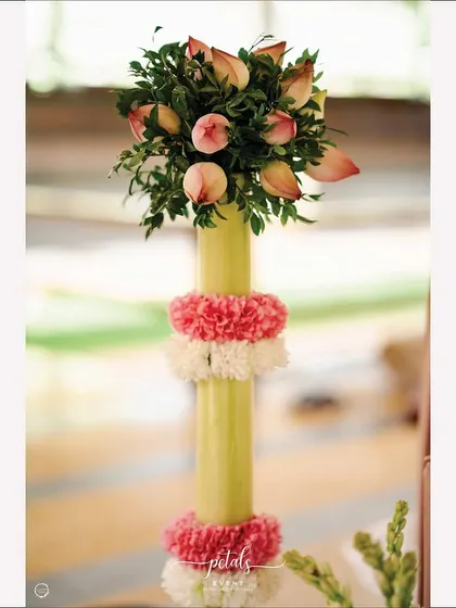 A close-up of a banana stem pillar, adorned with flowers, a classic element in South Indian ritual decor.