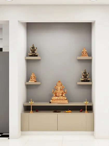 A simple and elegant pooja niche with floating shelves for multiple idols. The neutral grey color scheme is modern and calming.
