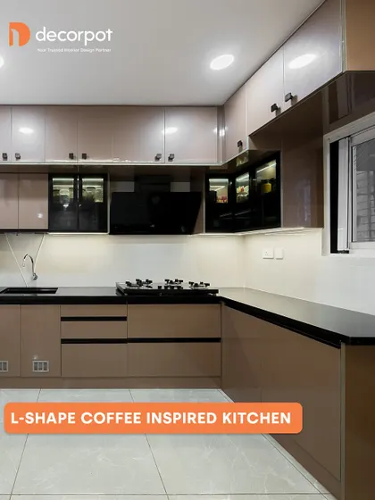Inspired by the rich tones of coffee, this L-shaped kitchen uses a warm brown laminate with a high-gloss finish. The black countertop and handles provide a bold contrast, resulting in a sophisticated and modern design.