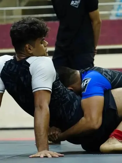 A close up of a grappling exchange in a tournament. Our fighter maintains a strong base while working to pass the guard, showcasing the technical patience we instill in our competitors.